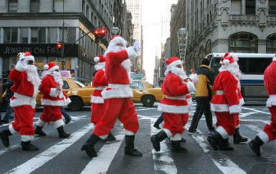 Santas wave as they cross the street during the Volunteers of America's 103rd annual Sidewalk Santa Parade along New York's Fifth Avenue late last month. The parade kicks off the Volunteers of America's fund-raising drive.
(Associated Press / The Spokesman-Review)
