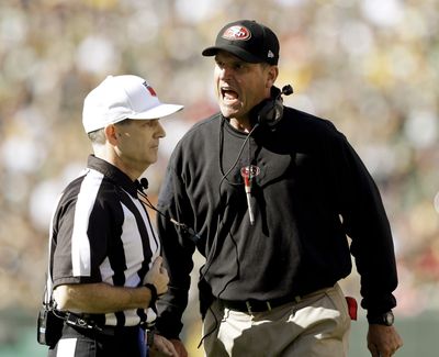 San Francisco 49ers head coach Jim Harbaugh argues a call with referee David White during the first half of a game against the Green Bay Packers on Sept. 9. (Associated Press)