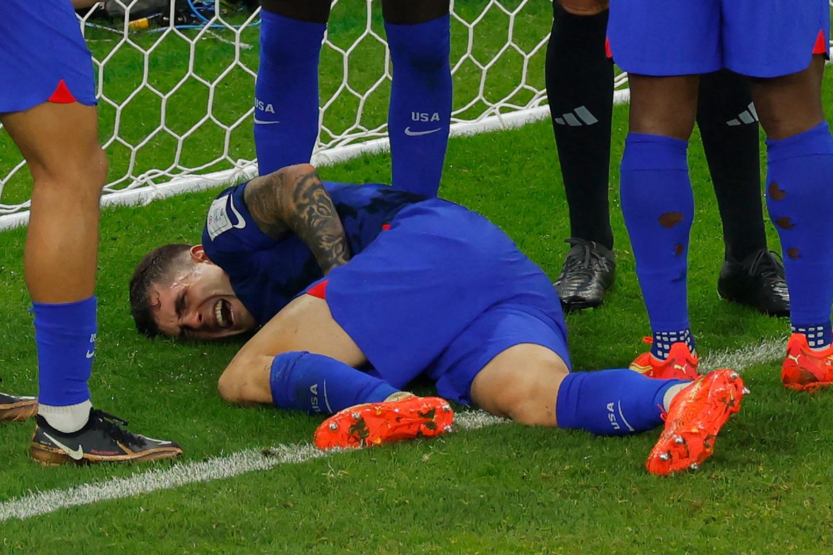 USA forward Christian Pulisic (10) reacts following a collision during the Qatar 2022 World Cup Group B football match between Iran and USA at the Al-Thumama Stadium in Doha on Nov. 29, 2022.  (Tribune News Service)