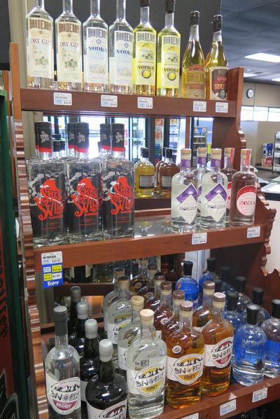 Idaho-made craft spirits are displayed on an Idaho-shaped shelf at a state liquor store in Boise on July 3, 2017. Idaho has designated July as “Idaho Spirits Month” to celebrate its small but growing artisan distilling industry. (Betsy Z. Russell / SR)
