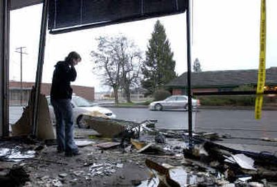 
Jennifer Bolles, branch manager at the US Bank at Indiana and Atlantic in Spokane, stands among the debris while talking with her district manager on a cell phone after a Honda Civic crashed through the bank's wall Saturday evening. No one was injured, but the bank suffered damage. 
 (Dan Pelle / The Spokesman-Review)