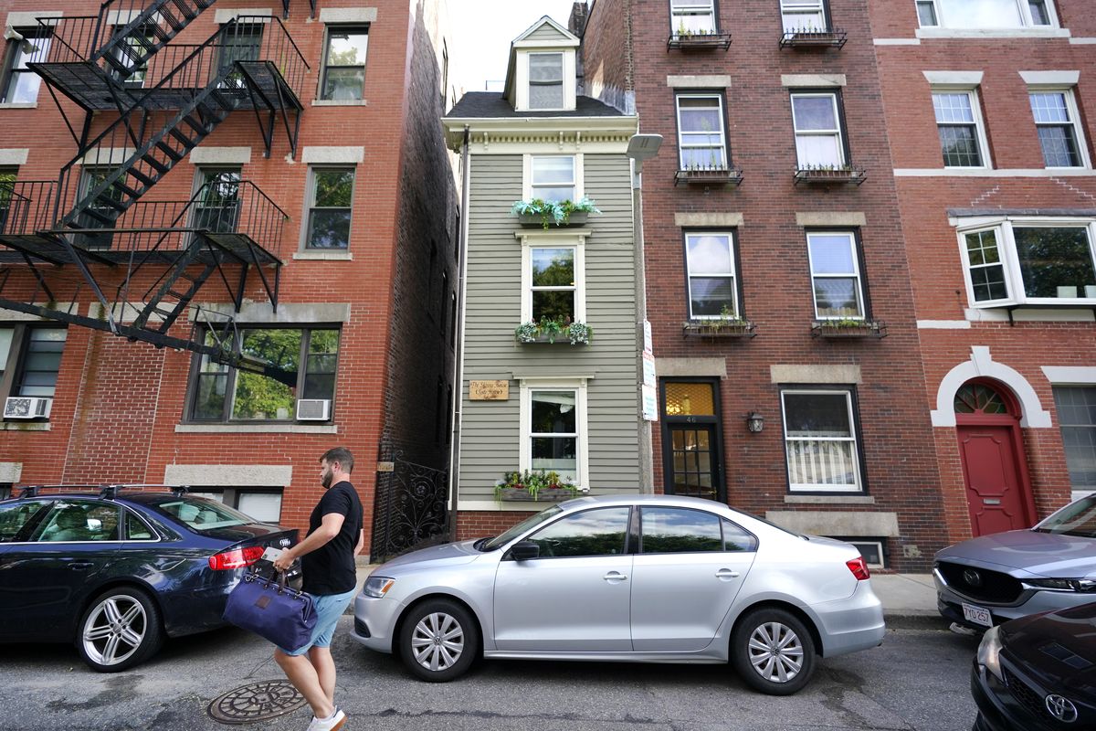 A man walks by Boston’s famous Skinny House on Friday. (Elise Amendola)