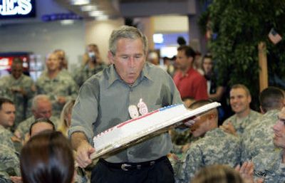 
President Bush blows out the candles on a birthday cake presented to him Tuesday during his lunch with military personnel and their families at Fort Bragg. Bush turns 60 on Thursday.
 (Associated Press / The Spokesman-Review)