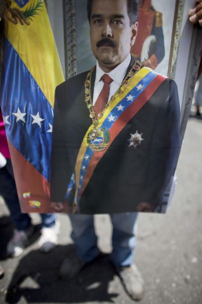 A government supporter holds an image of Venezuela's President Nicolas Maduro during an anti-imperialist march in Caracas, Venezuela, Tuesday, Sept. 19, 2017. (Ariana Cubillos / associated press)