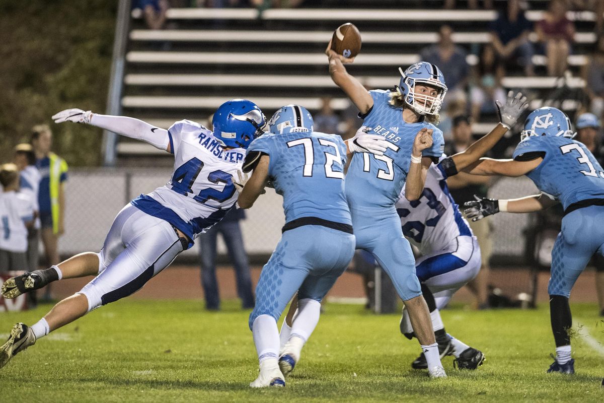 Central Valley QB Matt Gabbert (15) is pressured by Coeur d’Alene DL Cole Ramseyer (42), Sept. 1, 2017, in Spokane Valley. Wash. (Dan Pelle / The Spokesman-Review)