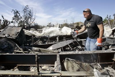David Bixler, 52, searches through the ashes of his home in Lake View Terrace, Calif., on Wednesday in search of his girlfriend’s ring.  (Associated Press / The Spokesman-Review)