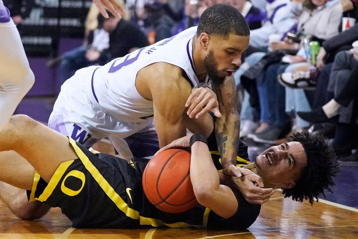 Washington guard Terrell Brown Jr., top, vies for a loose ball with Oregon guard Will Richardson, bottom, during the first half of an NCAA college basketball game Thursday, March 3, 2022, in Seattle. (Ted S. Warren)