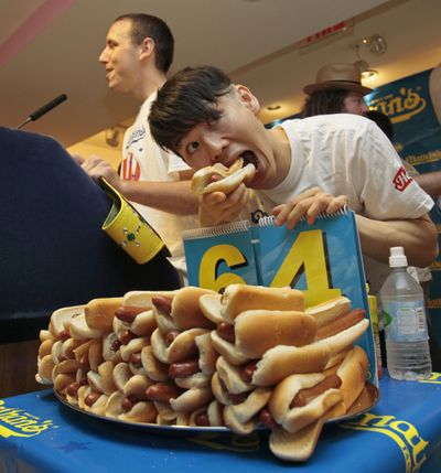 ORG XMIT: NYRD106 Joey Chestnut, left, of San Jose, Calif., defending champion of the Nathan's Famous July 4th Hot Dog Eating Contest, answers media questions as  former champion Takeru Kobayashi, of Nagano, Japan, poses for photos in New York,  Thursday, July 2, 2009. (AP Photo/Richard Drew) (Richard Drew / The Spokesman-Review)