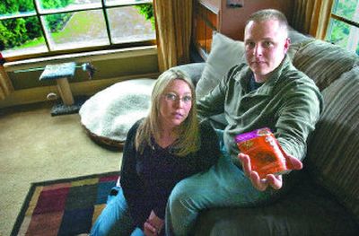 
Carrie and Darren Johannesen still have their cat toys and bed by the front window of their Spokane home. They are seen here Tuesday holding a package of the tainted Iams food they believe killed Pixie. 
 (Christopher Anderson / The Spokesman-Review)