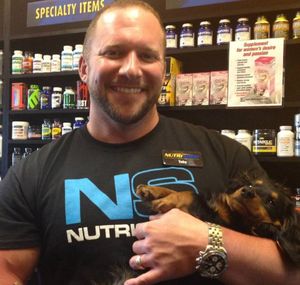 Coeur d'Alene City Council candidate Toby Schindelbeck and a pup in his nutrition store in Coeur d'Alene. (From: Toby Schindelbeck for City Council 2015)