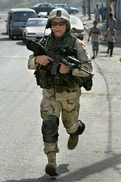 
A U.S. Army soldier runs near Haifa Street on Thursday in Baghdad, Iraq. One Iraqi police officer and another Iraqi suffered gunshot wounds in an overnight clash in the area. 
 (Associated Press / The Spokesman-Review)