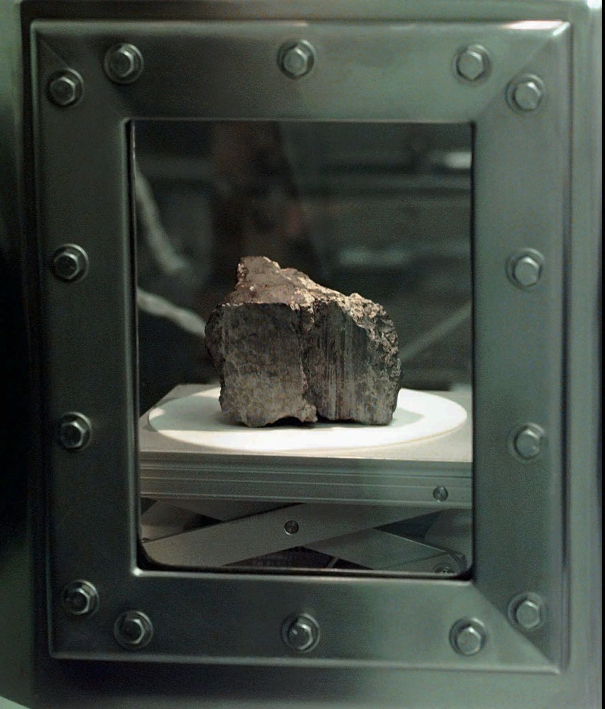 The meteorite labeled ALH84001 sits in a chamber at a Johnson Space Center lab in Houston, Aug. 7, 1996. Scientists say they've confirmed the meteorite from Mars contains no evidence of ancient Martian life. The rock caused a splash 25 years ago when a NASA-led team announced that its organic compounds may have been left by living creatures, however primitive. Researchers chipped away at that theory over the decades. A team of scientists led by Andrew Steele of the Carnegie Institution published their findings Thursday, Jan. 13, 2022.  (DAVID J. PHILLIP)