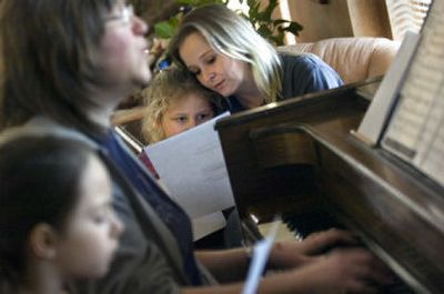 
Lynn Blumer, right, sits with her daughter Brooke Blumer, 5, while volunteer Sherilyn Jones, at piano, leads a small children's choir at St. Margaret's Shelter in Spokane on Thursday. Jones is a nurse at Sacred Heart Medical Center. 
 (Holly Pickett / The Spokesman-Review)