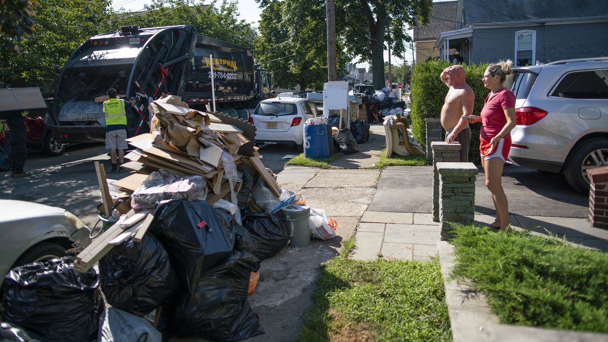 Residents wait a worker picking up debris, Monday, Sept. 6, 2021, in Passaic, NJ., from their flood damaged home in the aftermath of Hurricane Ida. (Eduardo Munoz Alvarez)