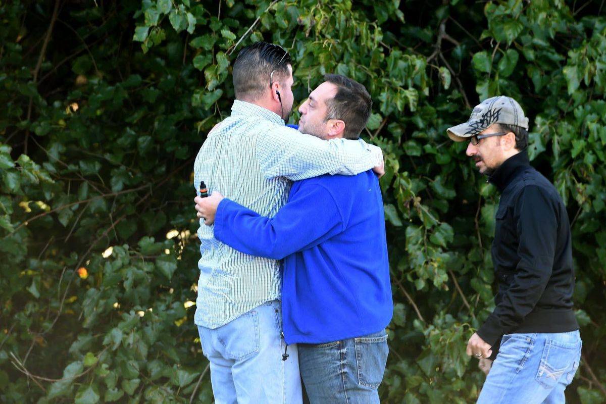Unidentified bystanders embrace as police and Emergency Medical Services respond to a shooting at a business park in the Edgewood area of Harford County, Md. (Matt Button / Associated Press)