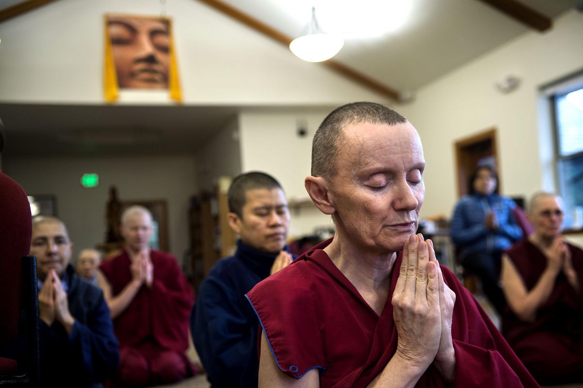 The Venereal Samten, front, prays before lunch at Sravasti Abbey, a Buddhist Monastery in Newport, Washington. (Kathy Plonka / The Spokesman-Review)