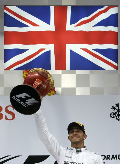 Lewis Hamilton of Britain holds up trophy after winning Chinese Grand Prix in Shanghai. (Associated Press)