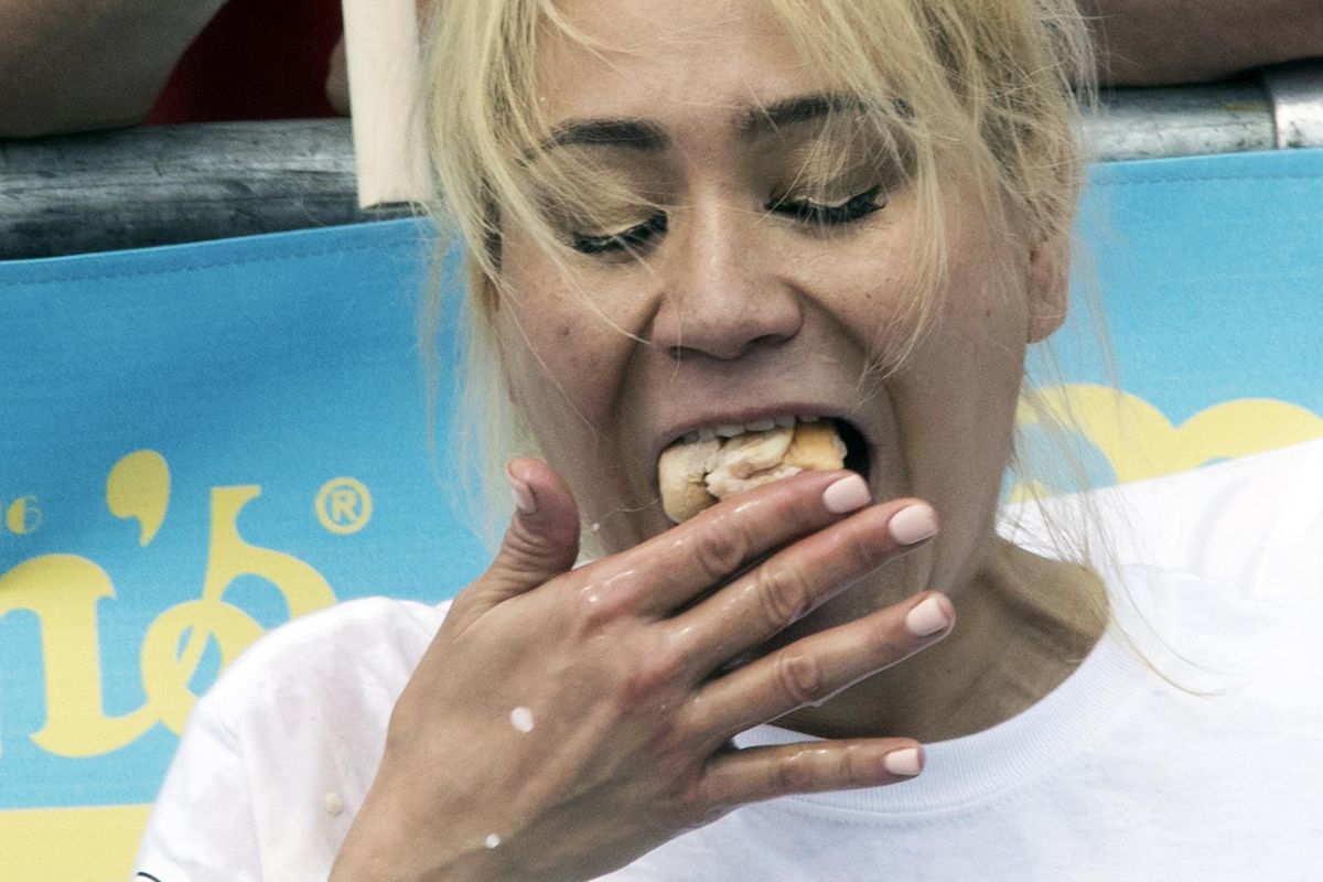 Reigning champion Midi Sudo eats hot dogs during the women