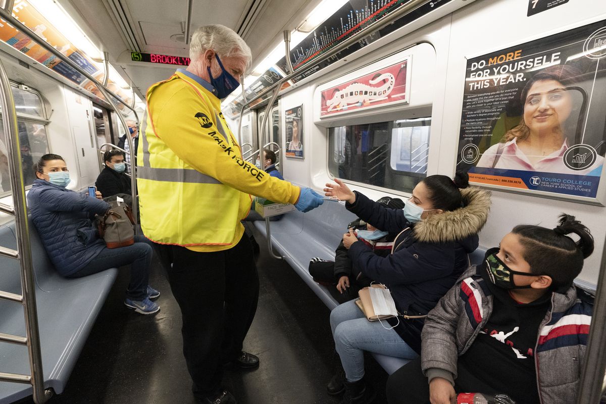 FILE - Patrick Foye, Chairman and CEO of the Metropolitan Transportation Authority, hands out face masks on a New York City subway, , Nov. 17, 2020, in New York. The Centers for Disease Control and Prevention is developing guidance that will ease the nationwide mask mandate for public transit next month. That