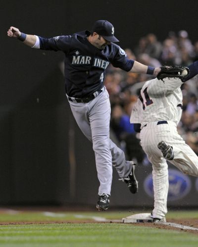 Twins' Ben Revere, right, avoids a tag from M’s Adam Kennedy for an infield single. (Associated Press)