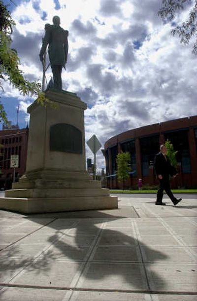 
Donald Morgan walks past a statue of John Robert Monaghan. The statue of Monaghan has been  at the corner of Riverside and Monroe in Spokane since 1906. 
 (KATE CLARK / The Spokesman-Review)