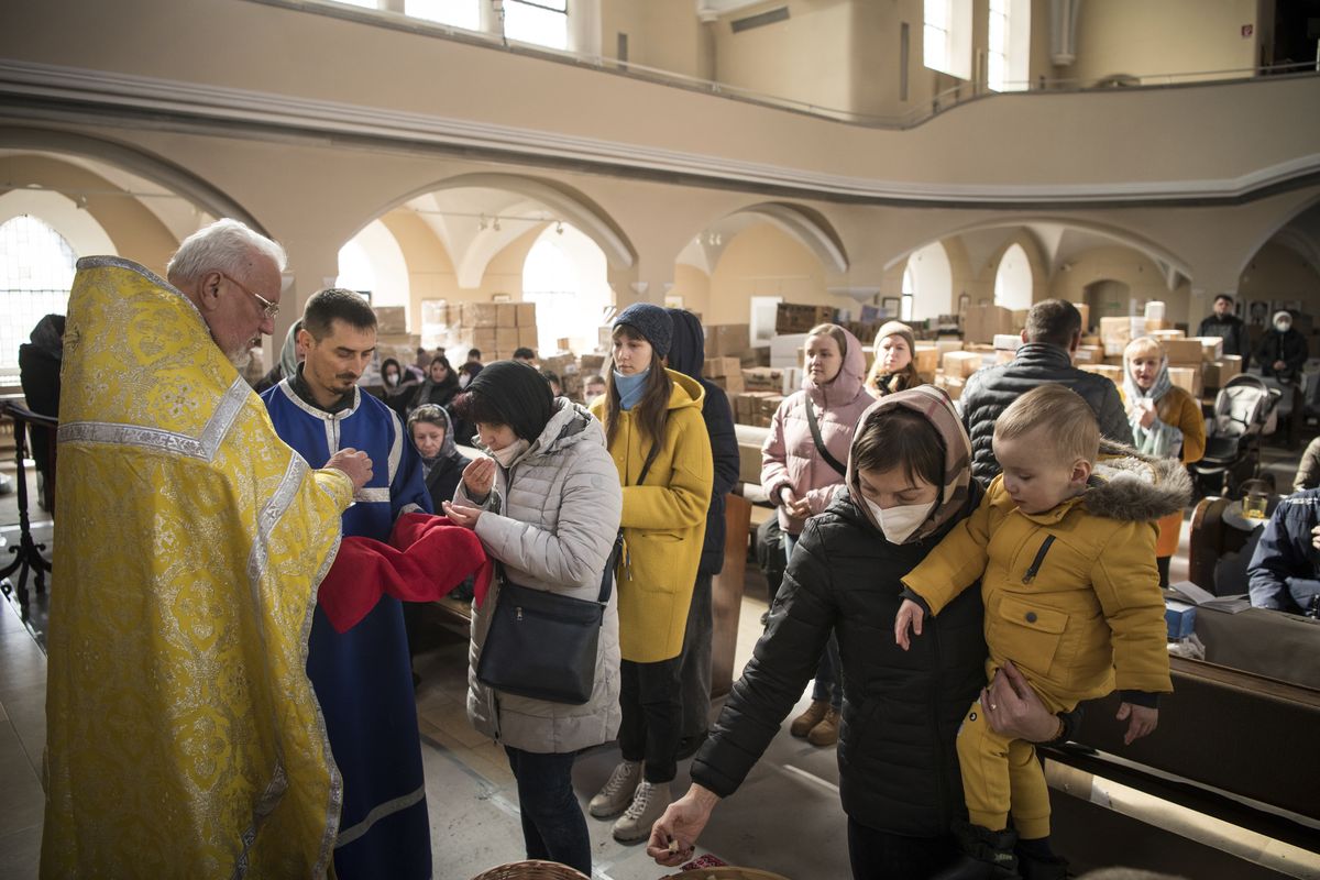 Members of the Ukrainian Orthodox community, who have found shelter for their church service in an evangelical church, and refugees from Ukraine celebrate a church service and pray for peace in Berlin, Sunday, March 20, 2022.  (Steffi Loos)