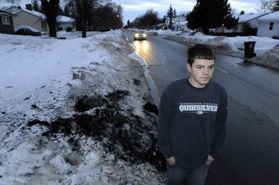 Joshua Myers stands Wednesday where a van crashed and burned  Tuesday near his home on North Belt Street in Spokane. Myers managed to break out a window and pull the driver to safety.  (Jesse Tinsley / The Spokesman-Review)