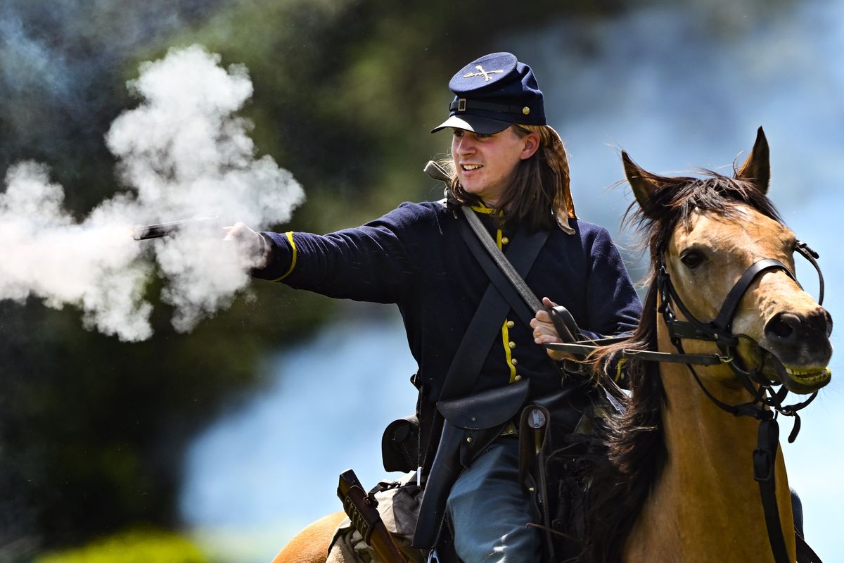 Reenactor Nigel Kelley takes a shot at Confederate soldiers from the back of Sugar the horse as the pair play the part of Union calvary members during the Battle for Siemers Farm Civil War Reenactment on Saturday, May. 24, 2025, in Green Bluff, Wash.  (Tyler Tjomsland/The Spokesman-Review)