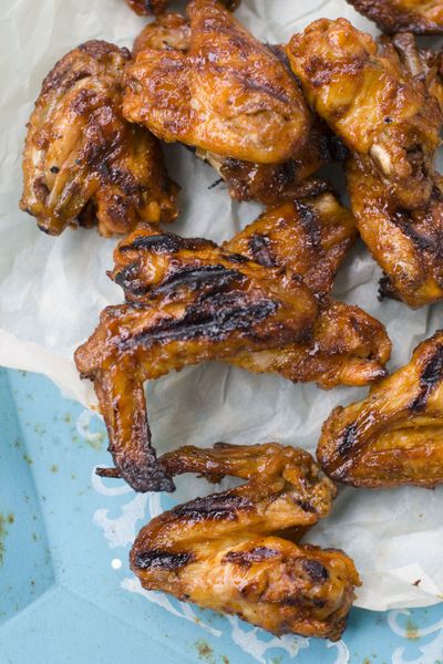 Try Sweet and Sticky HoneyHot Wings for Father’s Day. Marinate the chicken wings in hot sauce then grill them slowly. (Associated Press)