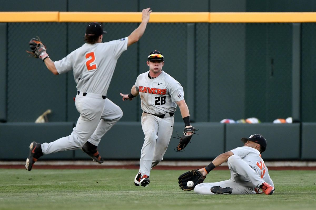 Oregon State’s Preston Jones (33) stops a ball as teammates Cadyn Grenier (2) and Kyle Nobach (28) close in during the fifth inning in Game 2 of the NCAA College World Series baseball finals in Omaha, Neb., Wednesday, June 27, 2018. Arkansas scored on the hit. (Ted Kirk / Associated Press)