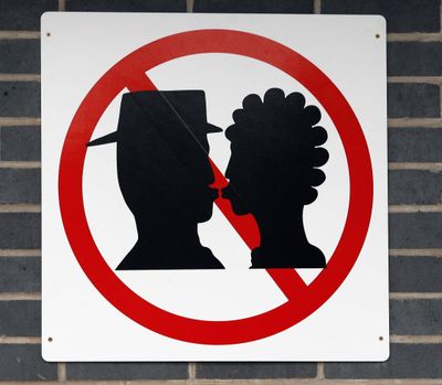 ORG XMIT: LON804 This No Kissing sign was unveiled at Warrington Bank Quay railway station in Warrington, England, Monday Feb. 16, 2009, in a bid to cut delays. The sign has been placed at the drop off point, because departing passengers and drivers block access to the station with their vehicles while saying goodbye to each other. Virgin Rail, which runs the station, says if passengers want to share an embrace before they part company, their loved ones should pay to park their cars nearby.(AP Photo/Peter Byrne/-pa)  **UNITED KINGDOM OUT: NO SALES: NO ARCHIVE:** (Peter Byrne / The Spokesman-Review)