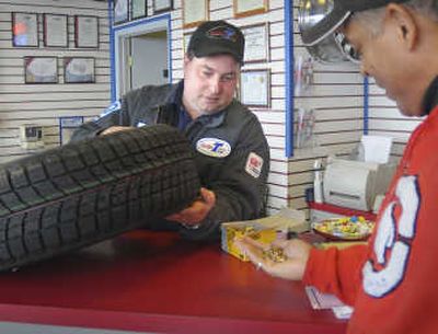 Manager Jeremy Dierks explains the features of snow tires and studs to Mitch Hicks at Perfection Tire on Monday.
(CHRISTOPHER ANDERSON / The Spokesman-Review)