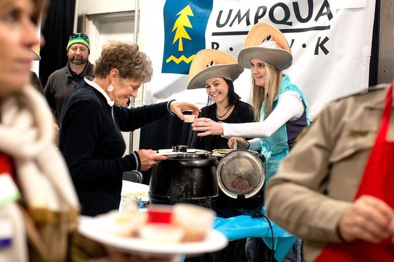 Sporting clam hats, Michaela Findley, right, and Shawny Le give Diana Bistline a sample of clam chowder Umpqua Bank cooked for the St. Vincent de Paul's 