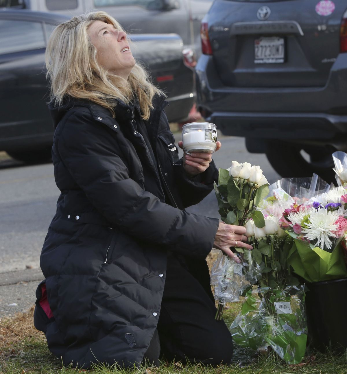 Andrea Jeager, of Hesperus, Colo., says a prayer as she places flowers and a candle at a makeshift memorial at a sign for the Sandy Hook school,  Saturday, Dec. 15, 2012 in Sandy Hook village of Newtown, Conn.  The massacre of 26 children and adults at Sandy Hook Elementary school elicited horror and soul-searching around the world even as it raised more basic questions about why the gunman, 20-year-old Adam Lanza, would have been driven to such a crime and how he chose his victims. (Mary Altaffer / Associated Press)