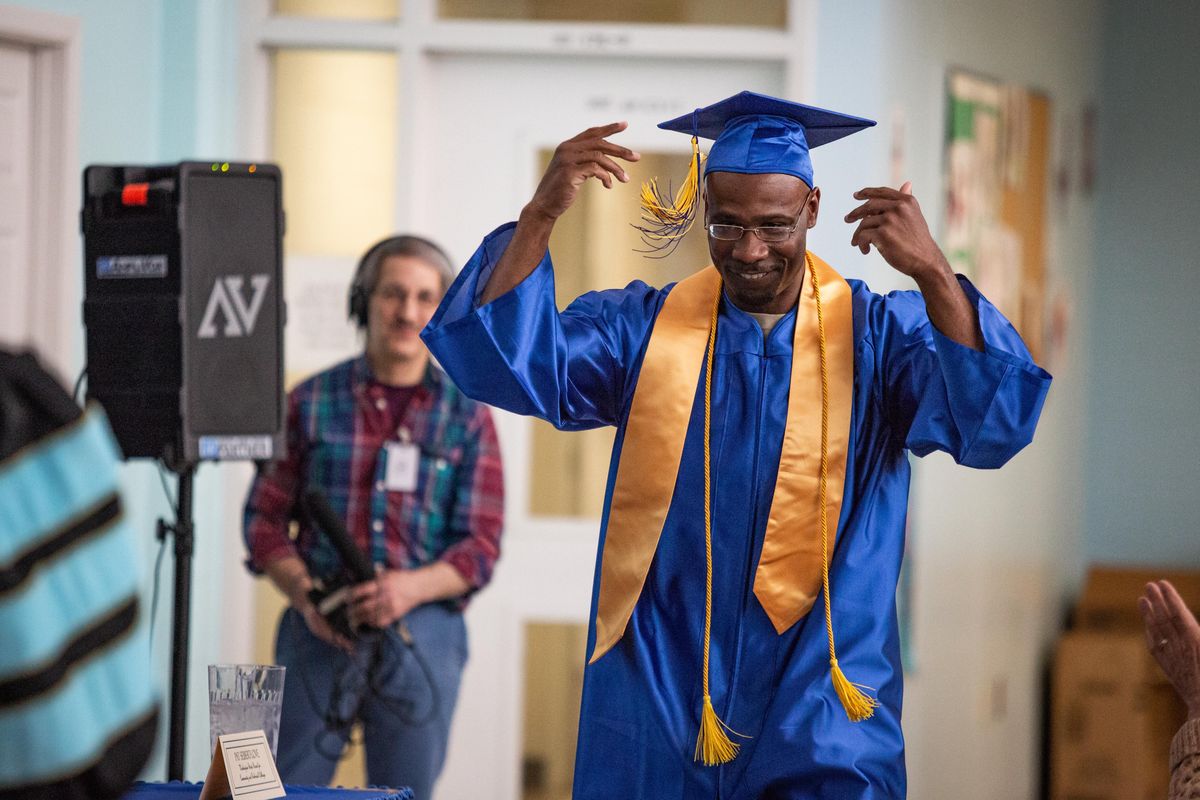 David Hall, 39, gestures eagerly while walking to receive his diploma from Spokane Community College President Kevin Brockbank during a commencement ceremony at Airway Heights Corrections Center on Thursday, April 25, 2019. Hall was one of four Airway Heights prisoners to earn an associate degree while incarcerated. (Libby Kamrowski / The Spokesman-Review)