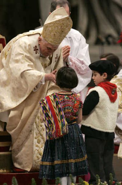 
Pope Benedict XVI receives gifts from children in native costumes as he celebrates the Christmas Midnight Mass in St. Peter's Basilica at the Vatican early today. Associated Press
 (Associated Press / The Spokesman-Review)