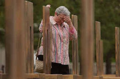 
Gloria Taylor pauses to collect her thoughts after hanging a wreath on her daughter's memorial chair at the Oklahoma City National Memorial on Monday.
 (Associated Press / The Spokesman-Review)