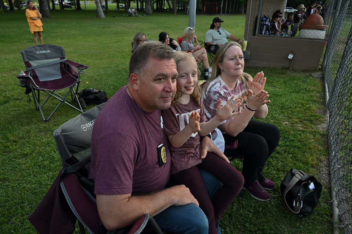 Celia Grace Hamlett, center, attends her brother’s baseball game with parents Gary and Kassie Hamlett in Winfield, Ala., in May. The 7-year-old was the first person in the United States to receive a new pricey gene therapy to treat a rare neurodegenerative disease.  (Michael S. Williamson/Washington Post)