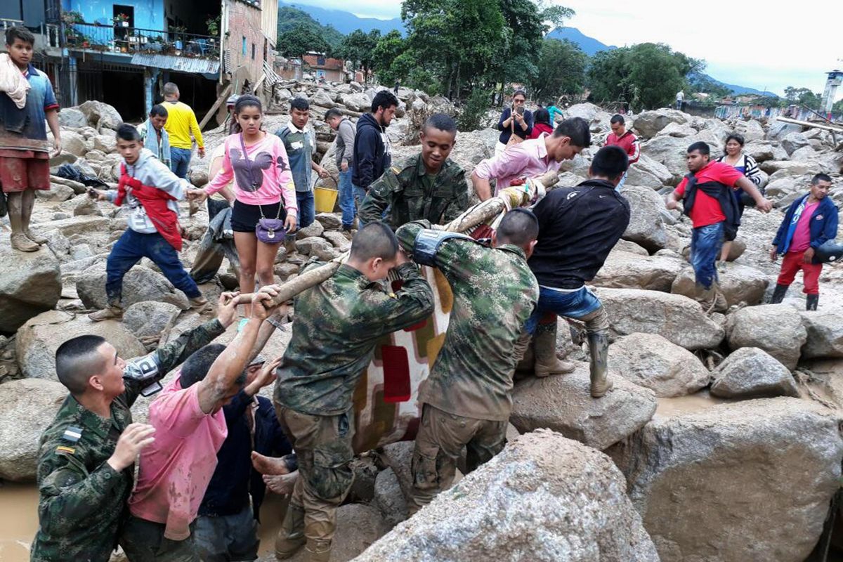 Soldiers and residents work together in rescue efforts in Mocoa, Colombia, Saturday, after an avalanche of water from an overflowing river swept through the city as people slept. The incident triggered by intense rains left at least 150 people dead in Mocoa, located near Colombia