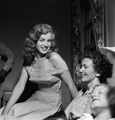 Marilyn Monroe, left, presents Photoplay Magazine’s “Dream House” contest winner Virginia McAllister and her son with the key to a new house in June 1949 in Warrenburg, New York. Monroe was in New York to promote the film “Love Happy.” Five photos of Monroe from 1949 by photographer John Ahlhauser are up for auction.  (Hulton Archive/Getty Images North America/TNS)