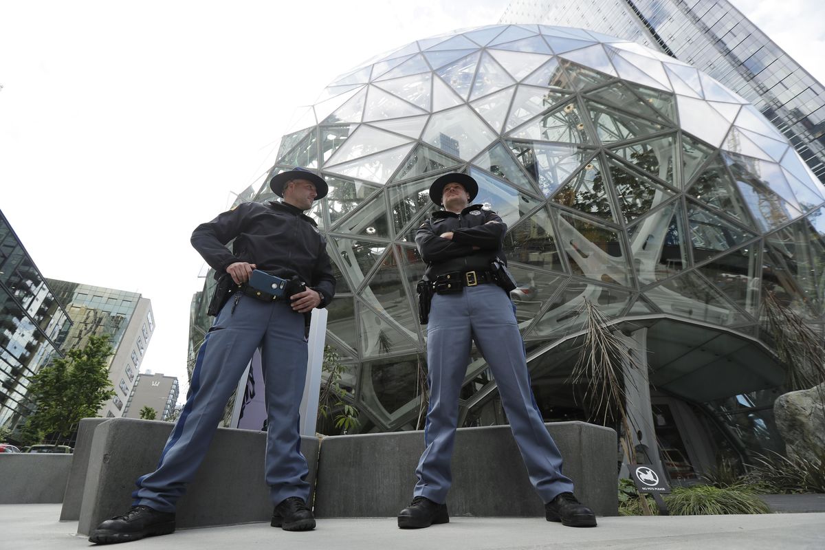 Two Washington State Troopers stand guard at the Amazon Spheres on May Day, Tuesday, May 1, 2018, in Seattle. The Seattle Police Department said on Twitter that a man was arrested earlier in the day for throwing a rock at the Spheres. (Ted S. Warren / Associated Press)