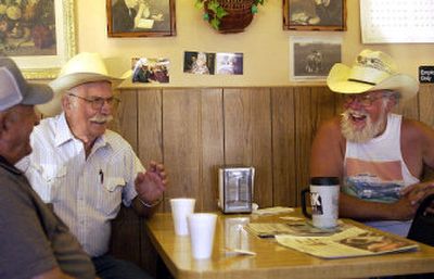 
Arlo Huber, left, and Del Murphy, right, listen as Jim Patterson tells a story over their morning coffee at Something Sweet Doughnut House in Otis Orchards. 
 (Liz Kishimoto / The Spokesman-Review)