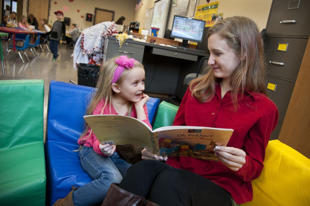 Ferris High School junior Rebecca Haynes, 17, reads a Winnie the Pooh book titled “Oh, Bother! Someone’s Messy” to Ferris Preschool student Bryn Johnson, 4, during morning class time Tuesday. (PHOTOS BY DAN PELLE)