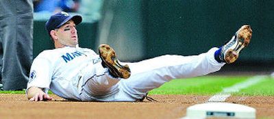 
M's third baseman Willie Bloomquist watches his late throw to first.
 (Associated Press / The Spokesman-Review)