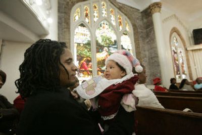Alfred Davis holds his daughter Alachae, 4 months, during services at the First Emmanuel Baptist Church on Christmas Day in New Orleans on Sunday.
 (Associated Press / The Spokesman-Review)