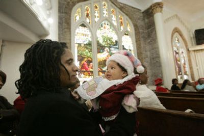 Alfred Davis holds his daughter Alachae, 4 months, during services at the First Emmanuel Baptist Church on Christmas Day in New Orleans on Sunday.
 (Associated Press / The Spokesman-Review)