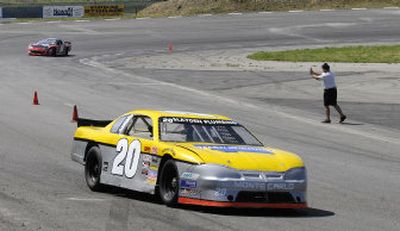 
Randy Koch gives hand signals to student drivers on the track at Stateline Speedway.
 (The Spokesman-Review)