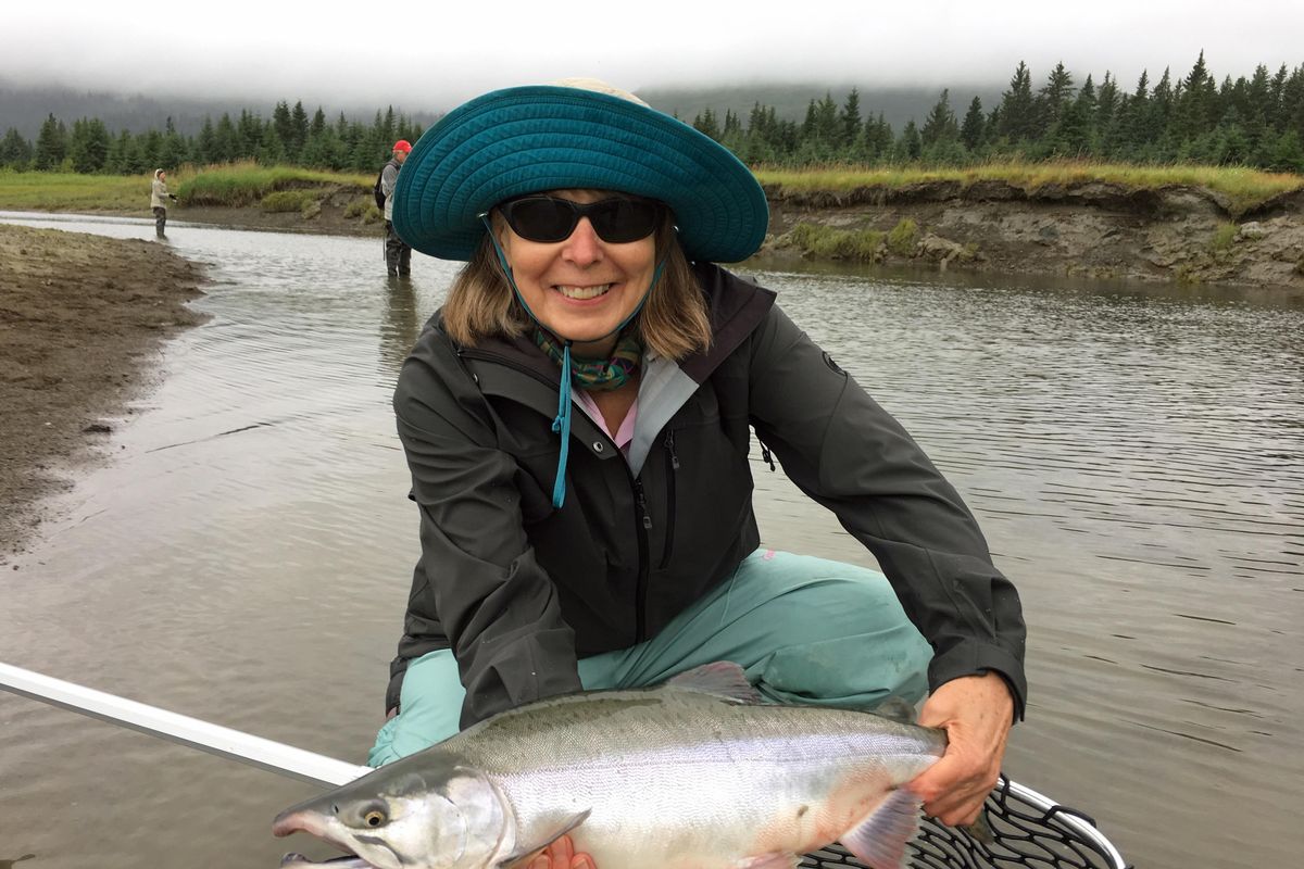 Mary Kay Rolwes releases a bright chum, one of several salmon species she caught while fly fishing out of Silver Salmon Creek Lodge in Alaska. (JERRY ROLWES / Courtesy)