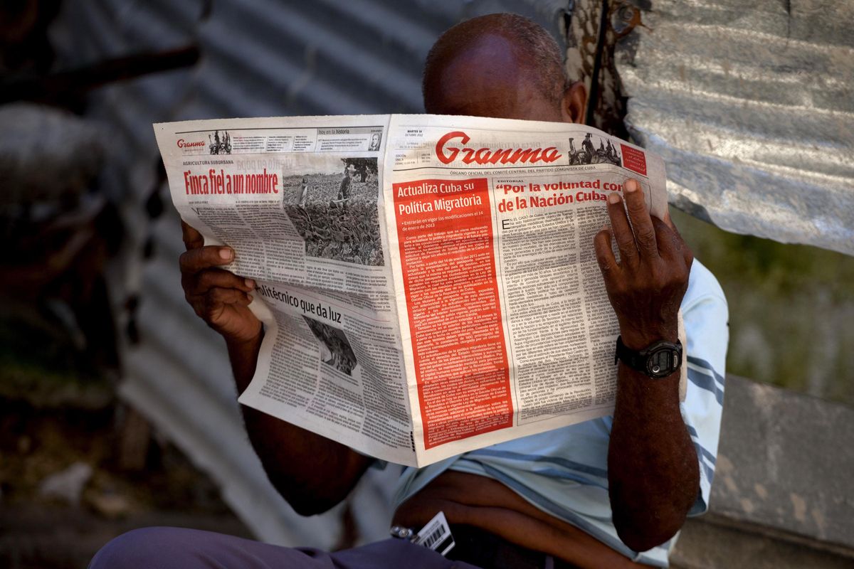 A man reads a Tuesday copy of the Communist Party newspaper Granma which published the new migratory policy that will no longer require islanders to apply for an exit visa on it