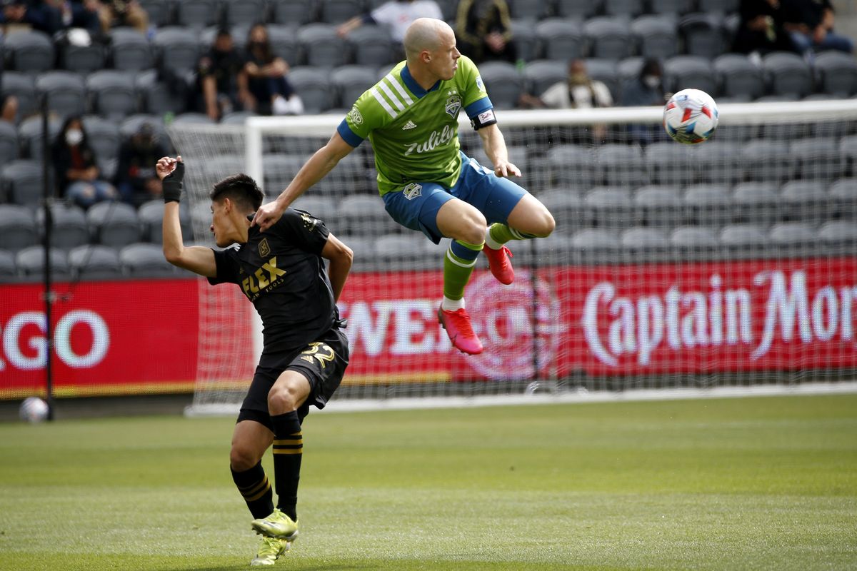Seattle Sounders defender Brad Smith, right, goes up for the ball next to Los Angeles FC mdefended Marco Farfan (32) during the first half of an MLS soccer match, Saturday, April 24, 2021, in Los Angeles. (Associated Press)